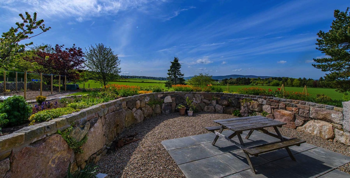 hand-crafted dry stone wall surrounding patio area of a renovated home in Aberdeenshire
