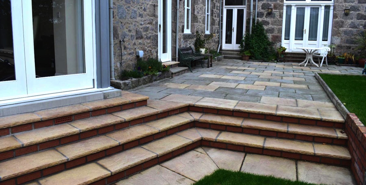 fully landscaped garden including hand-crafted stone steps leading up to fully paved patio area