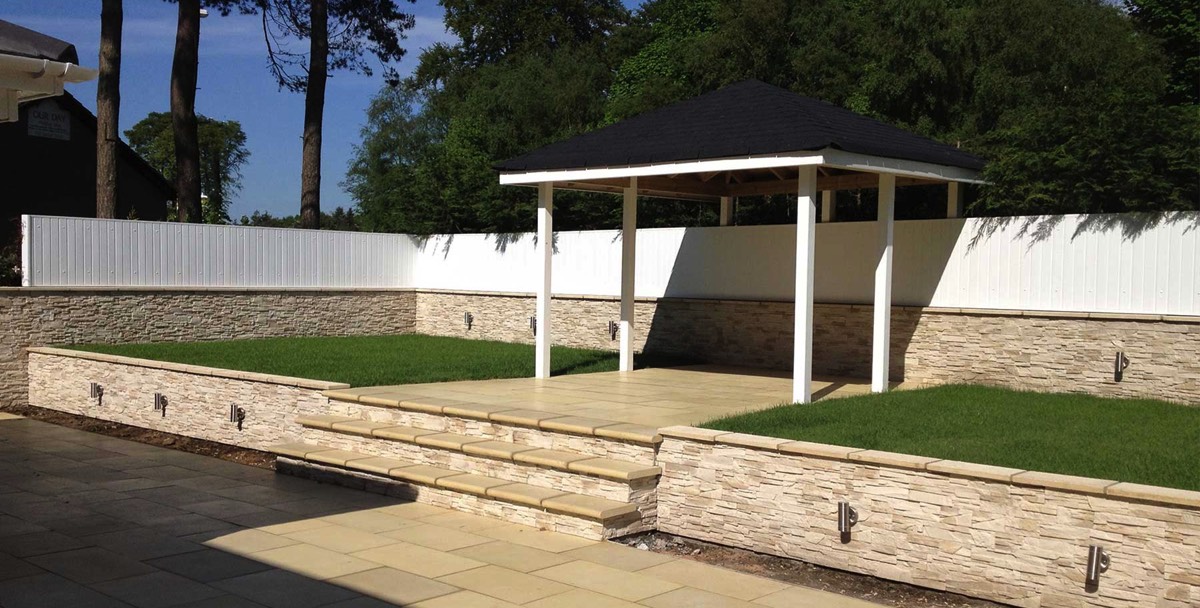recently completed landscaping project complete with step leading up from the patio area to a covered BBQ area